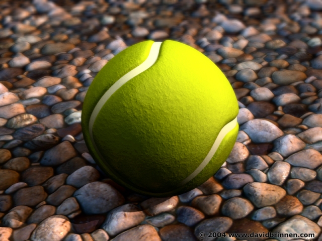 A tennis ball on some wet pebbles